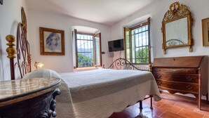 A bedroom with a bed, dresser, TV, and artwork. - 1 bedroom lovely apartment in Mezzanego (Mezzanego)
