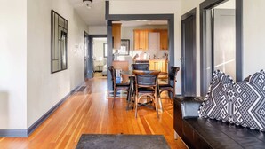 A modern living room with a wooden floor, a black leather sofa, and patterned cushions. - 2BR - Sleeps 6 - Perfect Location for Foodies (Portland)