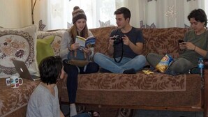 A living room with a sofa, a coffee table with books and a laptop, and a lamp. - Friendly Hostel (Gjirokaster)