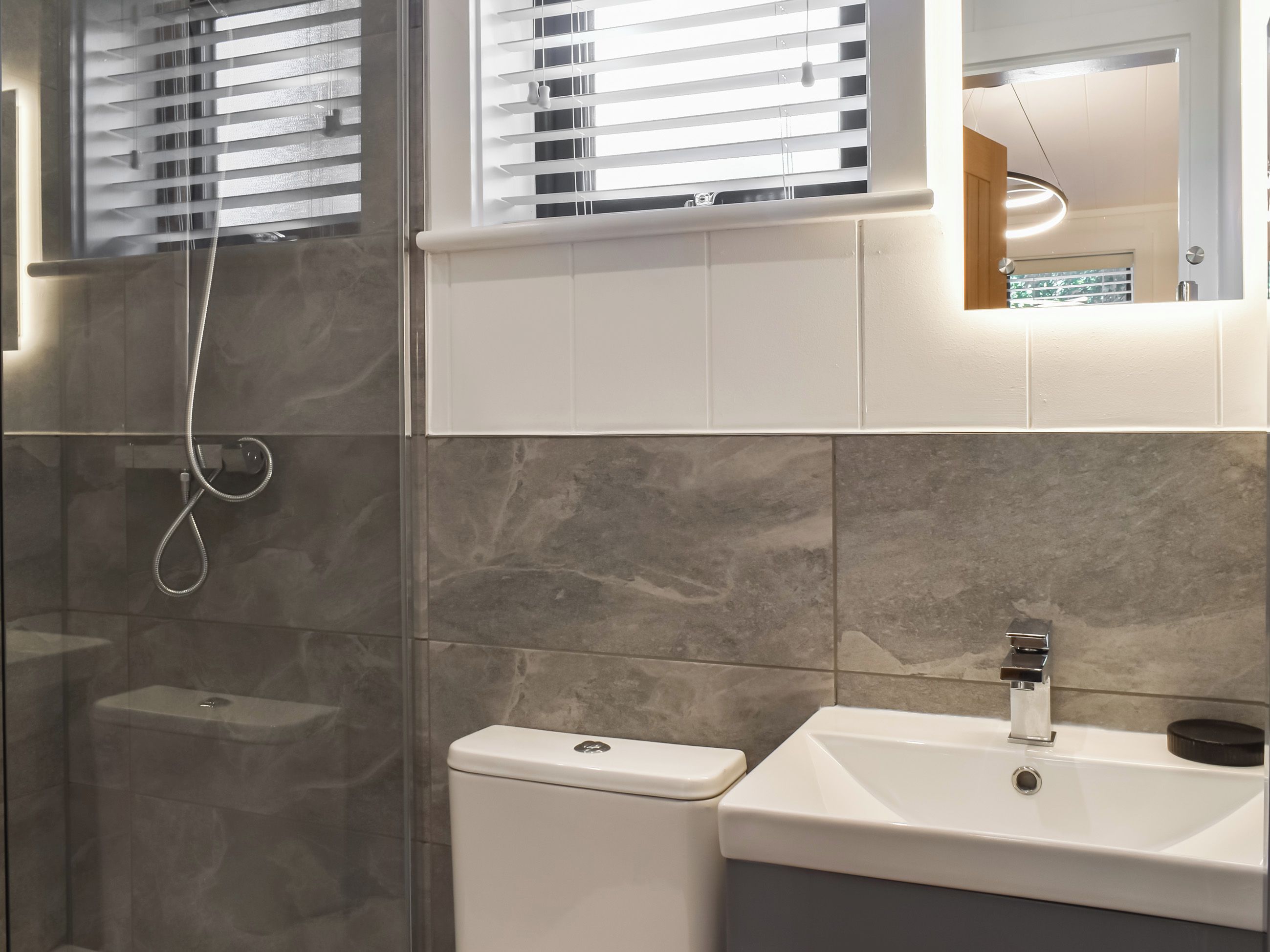 Une salle de bain avec douche, toilettes et lavabo.