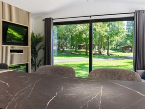 A modern room with a large window, a flat-screen TV, and a marble table. - 2 bedroom accommodation in Ingleton (Ingleton)