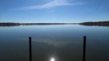 A wooden dock extending into calm water with a clear sky above.