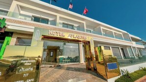 A hotel named "Atlantis" with a modern facade, multiple flags, and a clear entrance. - Hotel Atlantis Mazagan (Moulay Abdallah)