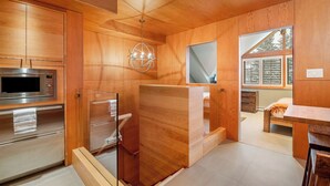 Una cocina moderna con armarios de madera, un microondas integrado y una lámpara colgante.