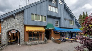 Un edificio de dos pisos con fachada de piedra y techo azul.