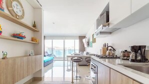 A modern kitchen with a central island, stainless steel appliances, and a view to the outside. - The Beach is Your Backyard! Ocean front, mountain views, and amazing sunset! (Santa Marta)