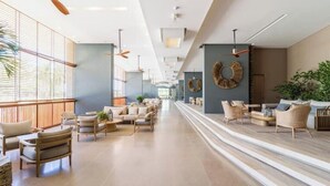 A spacious lobby with modern furniture, ceiling fans, and decorative wall elements. - The Beach is Your Backyard! Ocean front, mountain views, and amazing sunset! (Santa Marta)