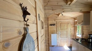 A wooden cabin interior with a kitchen area, a dining table, and a fireplace. - Tranquility and Natural Beauty Await at Our Secluded Finnish Chalet (Epe)