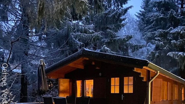 A wooden cabin with a porch, steps, and a table and chairs. - Tranquility and Natural Beauty Await at Our Secluded Finnish Chalet (Epe)