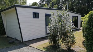 Een laag, rechthoekig gebouw met plat dak, een deur en een raam.