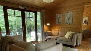 Un interior de madera con un sofá, una lámpara y obras de arte en la pared.