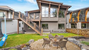 A modern two-story house with a patio area featuring outdoor furniture and a stone patio. - No Cleaning Fee!! King Sized Bed!!Nature All Around!! (Bighorn No. 8)