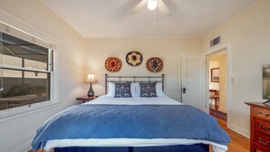 A bedroom with a large bed, a ceiling fan, and decorative wall art. - Charming / Outdoor Dining / 1 BR 1 BA / Sam Hughes (Tucson)