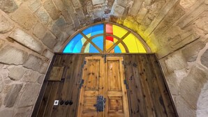 A stone-walled room with a wooden door and a stained glass window above it. - Obruk Kervansaray Museum Hotel (Konya)