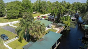 A riverside property with a dock, a covered outdoor area, and a parking lot.