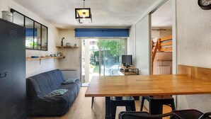 A compact living space with a sofa, a dining table, and a TV. - 1 bedroom nice apartment in Carnac (Carnac)