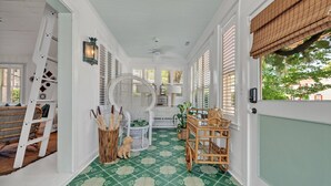 Una habitación soleada con piso de diseño verde, paredes blancas y una silla de madera.