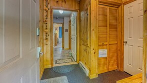 A wooden hallway with a door on the right and a door at the end of the hallway. - Riverfront Oasis at Loon (Lincoln)