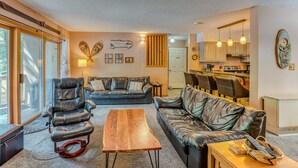 A cozy living room with leather sofas, a wooden coffee table, and a fireplace. - Riverfront Oasis at Loon (Lincoln)