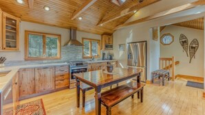 A spacious kitchen with wooden cabinets, a large island, and a built-in stove. - Private River Access & Mtn Views (Woodstock)