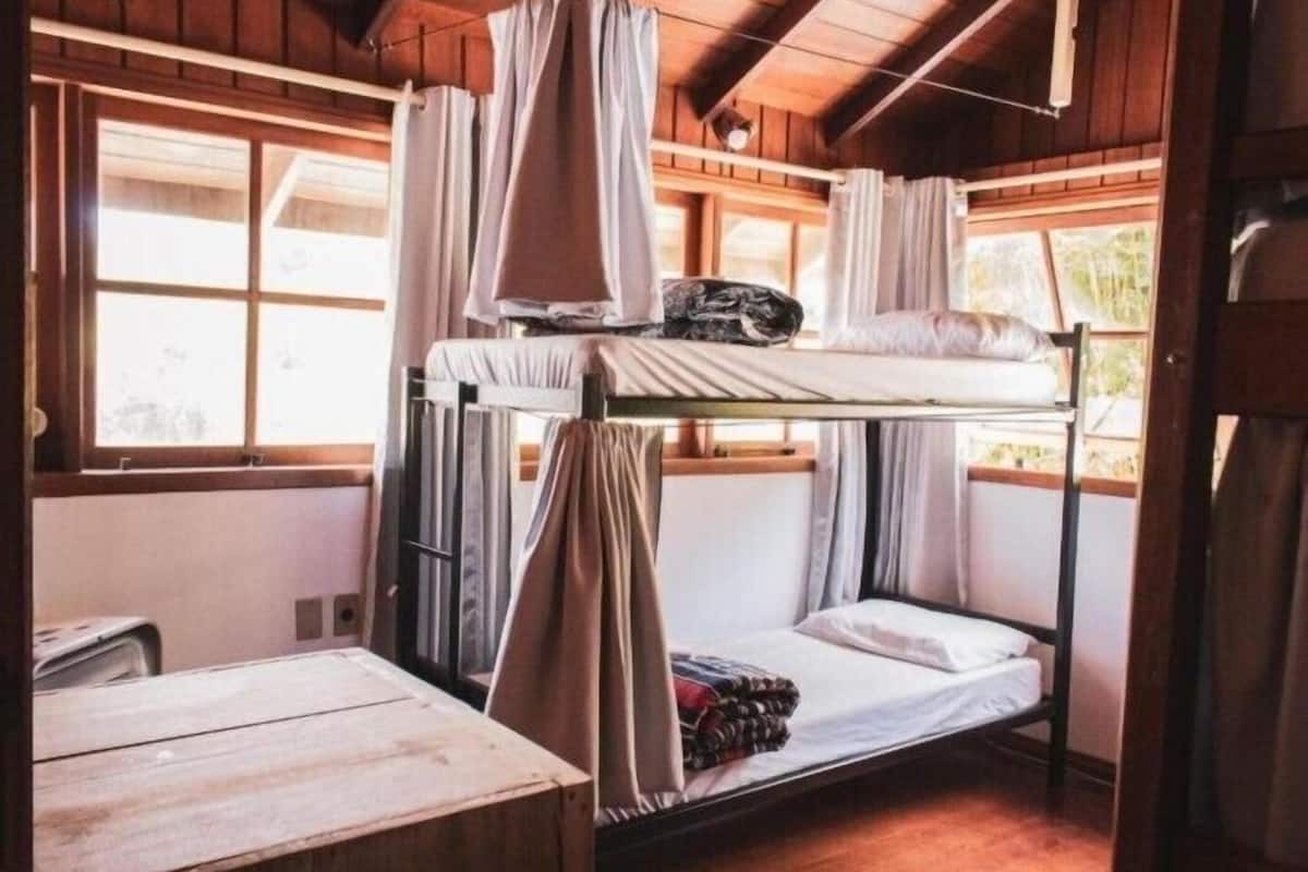 Une chambre avec un lit superposé, un plafond en bois et des fenêtres.