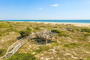 Une plage avec des promenades en bois et un paysage sablonneux.