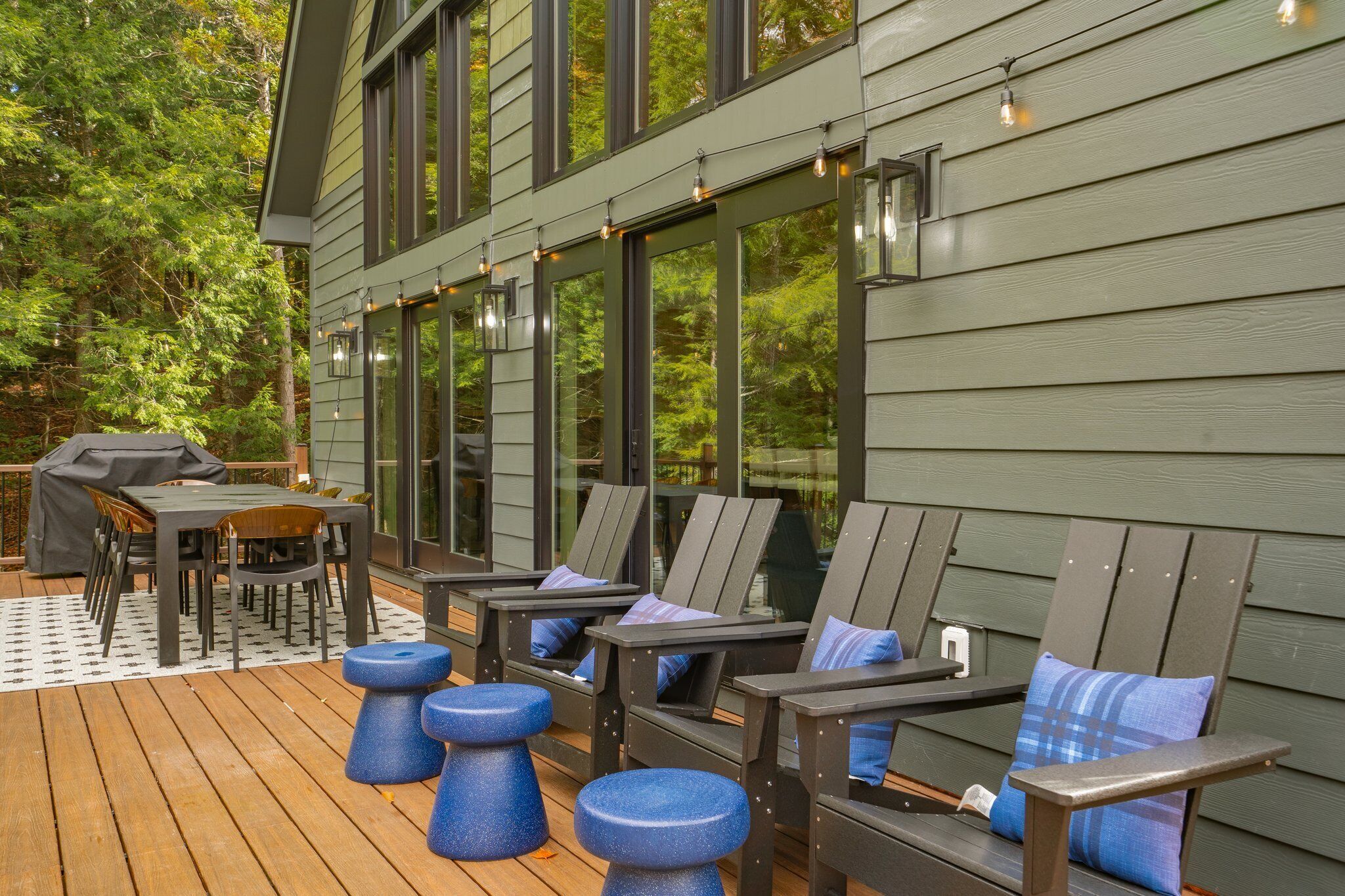 A deck with outdoor furniture, including chairs and a table, and a grill.