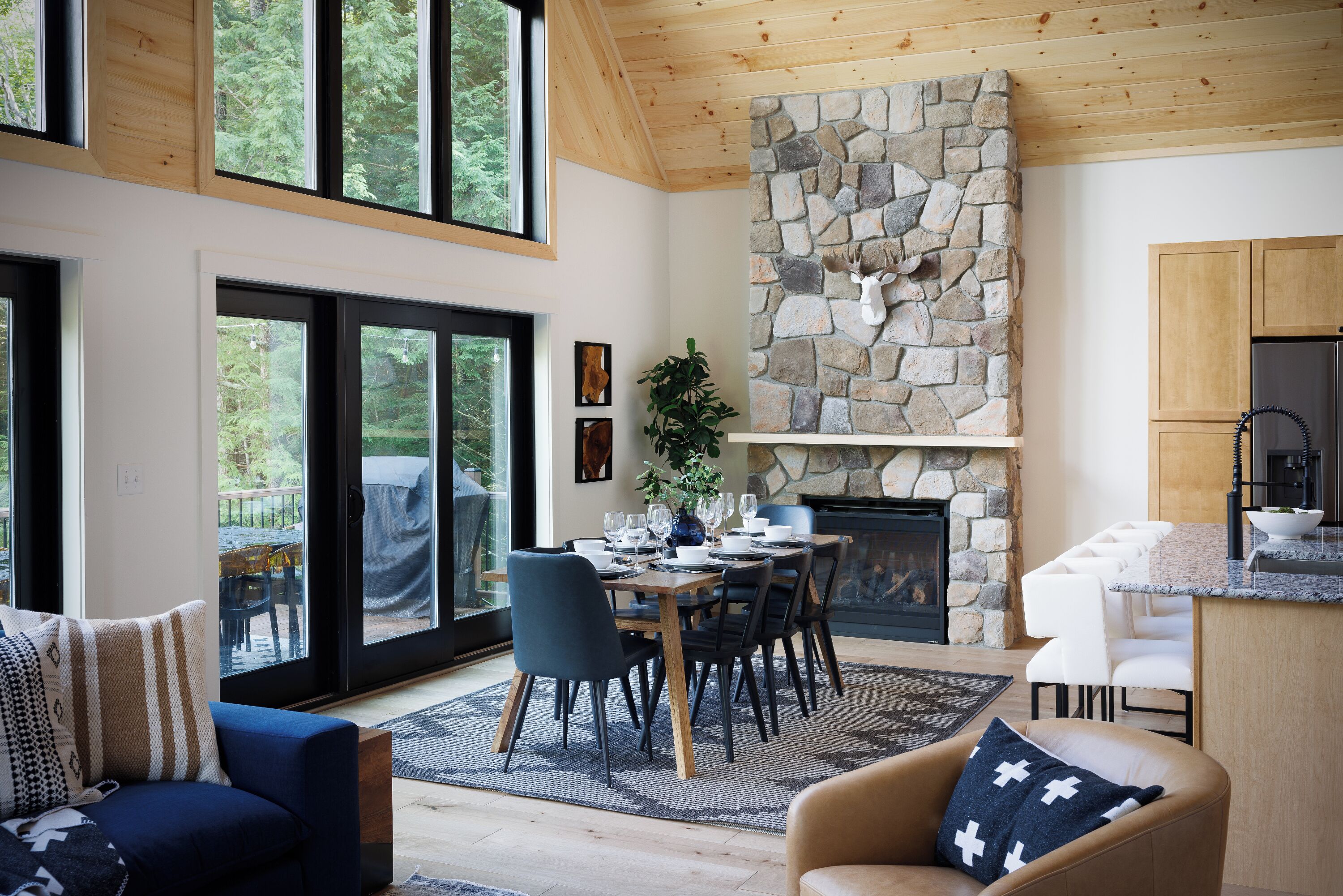 Un intérieur moderne avec une cheminée en pierre, un coin repas et une cuisine.