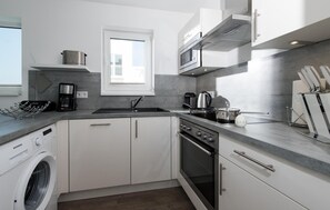 Een koelkast, een oven, een kookplaat, een vaatwasser
