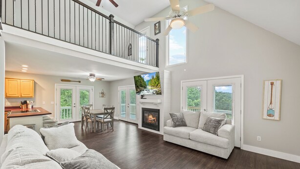 A spacious living room with a fireplace, a dining area, and a kitchen. - Breathtaking Views of Dale Hollow Lake (Monroe)