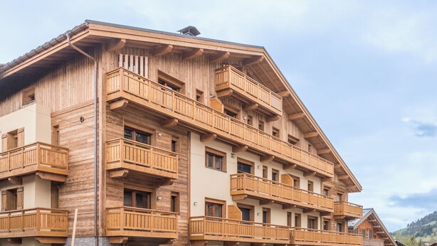 Un edificio de madera de varios pisos con balcones y ventanas.