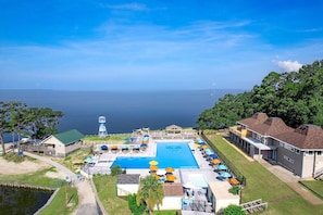 A resort with a large pool, outdoor seating, and a view of the ocean. - Canal Front Beach Days & Family Fun at Compass Cay (Kill Devil Hills)