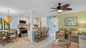 A spacious living area with a dining set, a sofa, and a ceiling fan. - 10125 Coral Coconut Cay - Condominium 2 Bedroom / 2 1/2Bath waterfront, maximum occupancy of 6 people. Community pool. (Bradenton)