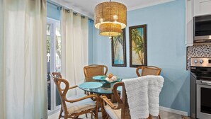 A dining area with wicker chairs, a glass table, and a hanging light fixture. - 10125 Coral Coconut Cay - Condominium 2 Bedroom / 2 1/2Bath waterfront, maximum occupancy of 6 people. Community pool. (Bradenton)