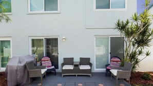 A patio with outdoor furniture, a covered grill, and a sliding glass door. - 10125 Coral Coconut Cay - Condominium 2 Bedroom / 2 1/2Bath waterfront, maximum occupancy of 6 people. Community pool. (Bradenton)