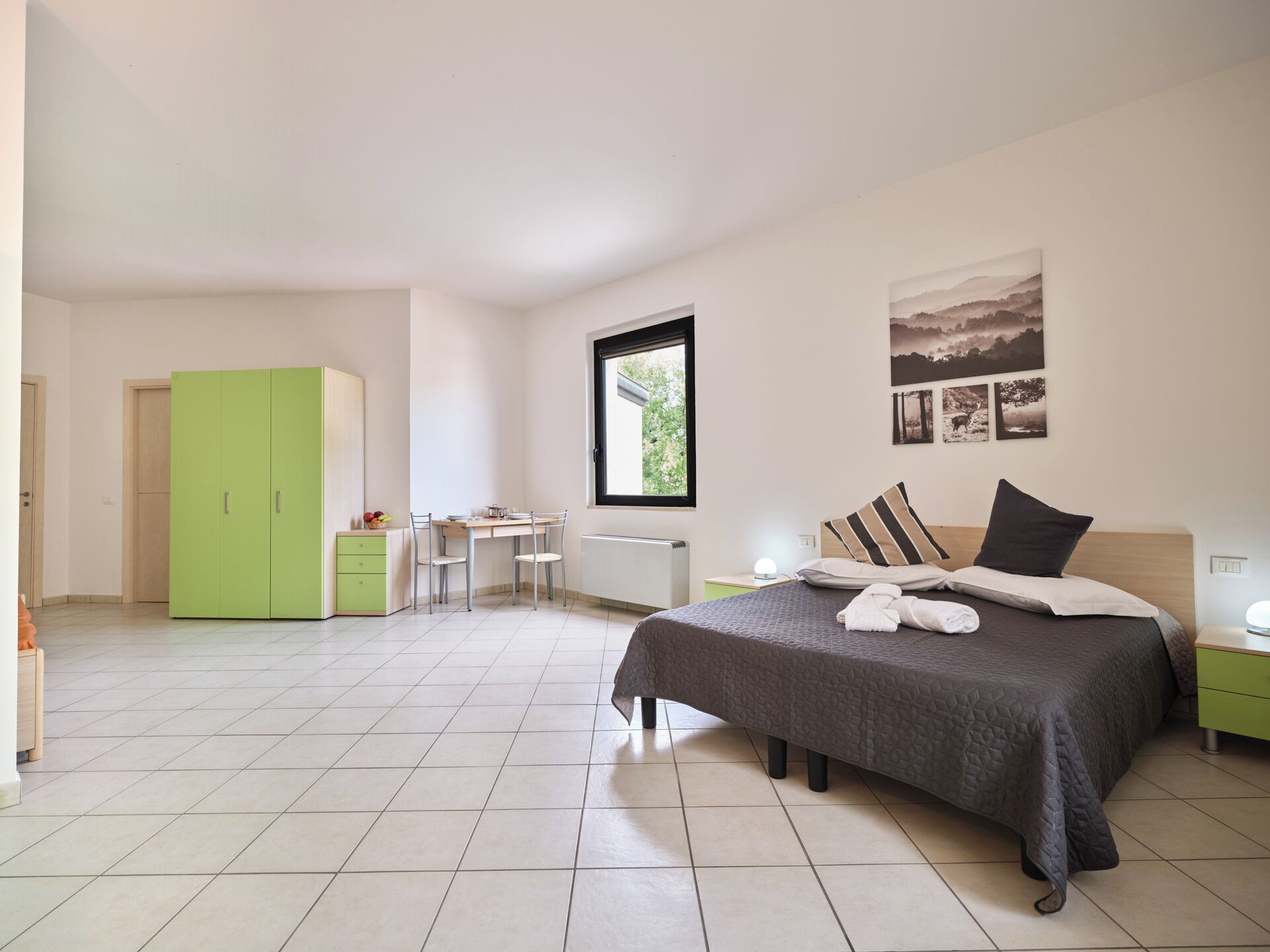 Une chambre à coucher avec un lit, un bureau et une armoire verte.