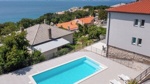 A pool area with a clear view of the sea and surrounding houses. - Villa Opera (Kvarner - Povile) (Povile)