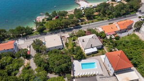 An aerial view of a coastal residential area with houses, a swimming pool, and a beach. - Villa Opera (Kvarner - Povile) (Povile)