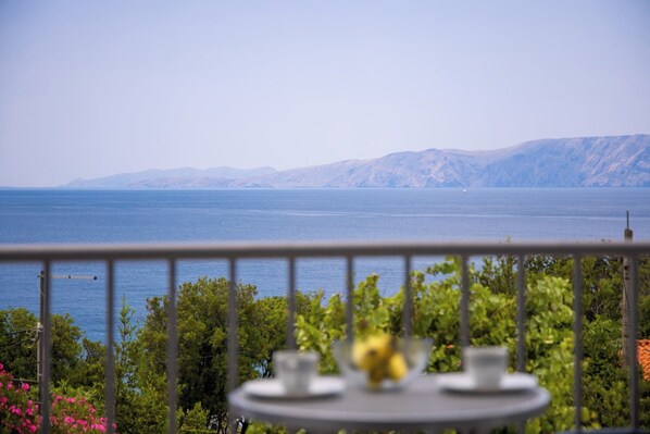 A balcony with a table, a view of the sea, and mountains in the background. - Villa Opera (Kvarner - Povile) (Povile)