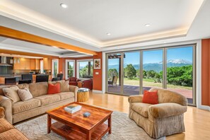 A spacious living area with a large sofa, a coffee table, and a view of a mountain through large sliding doors. - Gorgeous Views! 4 bedroom, Sleeps 10, contemporary home on 6.8 acres (Carbondale)
