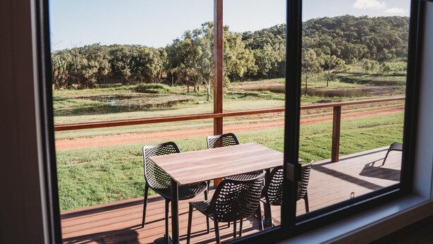 Una terraza con mesa y sillas que da a un paisaje pintoresco.