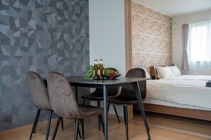A modern hotel room with a dining table, chairs, and a bed. - LAPIS LAZULI (Kamifurano)