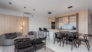 A modern kitchen with a dining area, a sofa, and a coffee machine. - Luxurious apartment in Novi Vinodolski with WiFi (Novi Vinodolski)