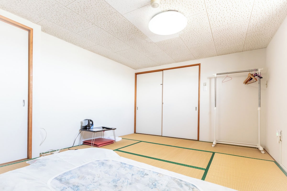 Une chambre avec un lit, un bureau, une armoire et un radiateur.