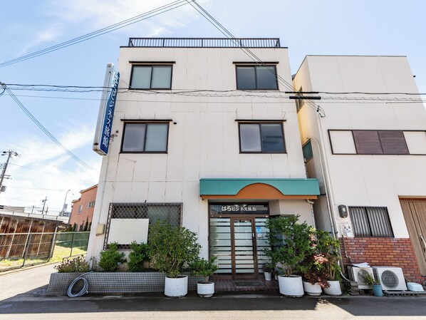 Un bâtiment moderne à la façade plate, doté de nombreuses fenêtres et d’une enseigne indiquant qu’il s’agit d’un établissement commercial.