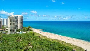 A coastal hotel with multiple high-rise buildings, a beach, and lush greenery. - Palm Beach Singer Island Resort & Spa Luxury Suites 2/2 Ocean View (Riviera Beach)