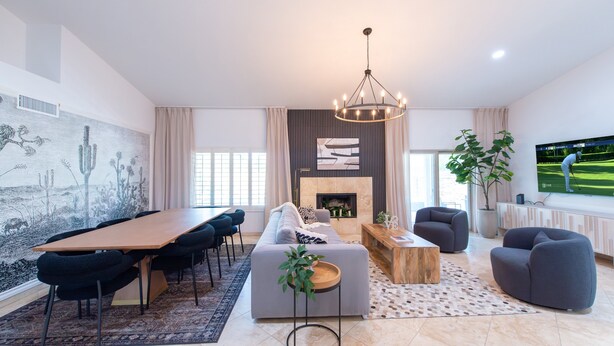 A modern living room with a dining area, a fireplace, and a large TV screen. - Welcome to Casa Jubilant Cacti by HomeSlice Stays (Phoenix)