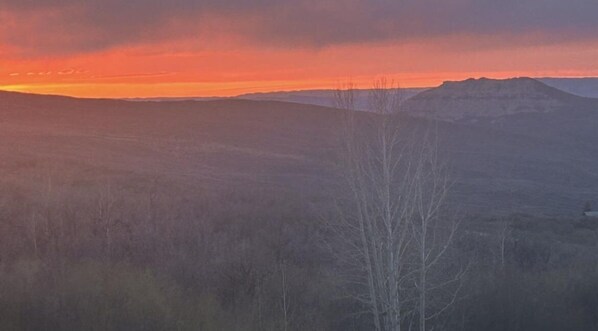 A mountainous landscape with a clear sky during sunset.