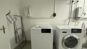 A laundry room with two front-loading washing machines and a drying rack. - Sunnmatt West Wohnung 933 Appartement/Fewo 5-Bettwohnung by Interhome (Engelberg)