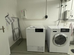 A laundry room with two front-loading washing machines and a drying rack. - Sunnmatt West Wohnung 933 Appartement/Fewo 5-Bettwohnung by Interhome (Engelberg)